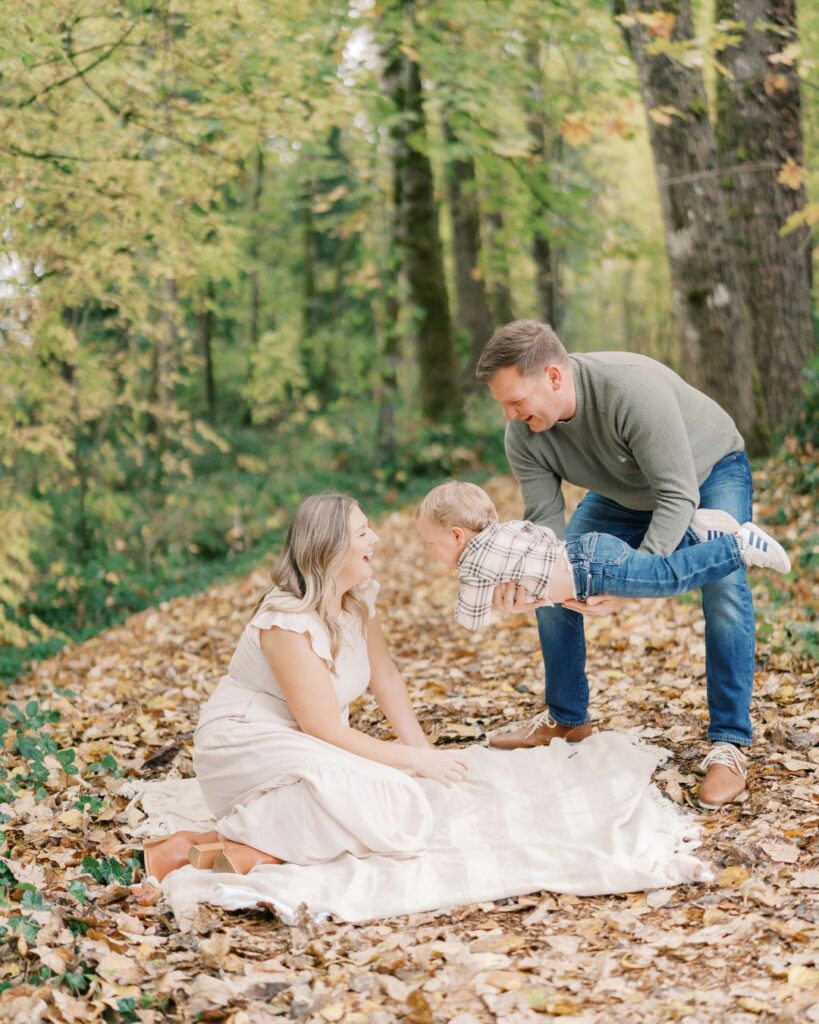 family of three plays during a fall forest mini session near portland oregon