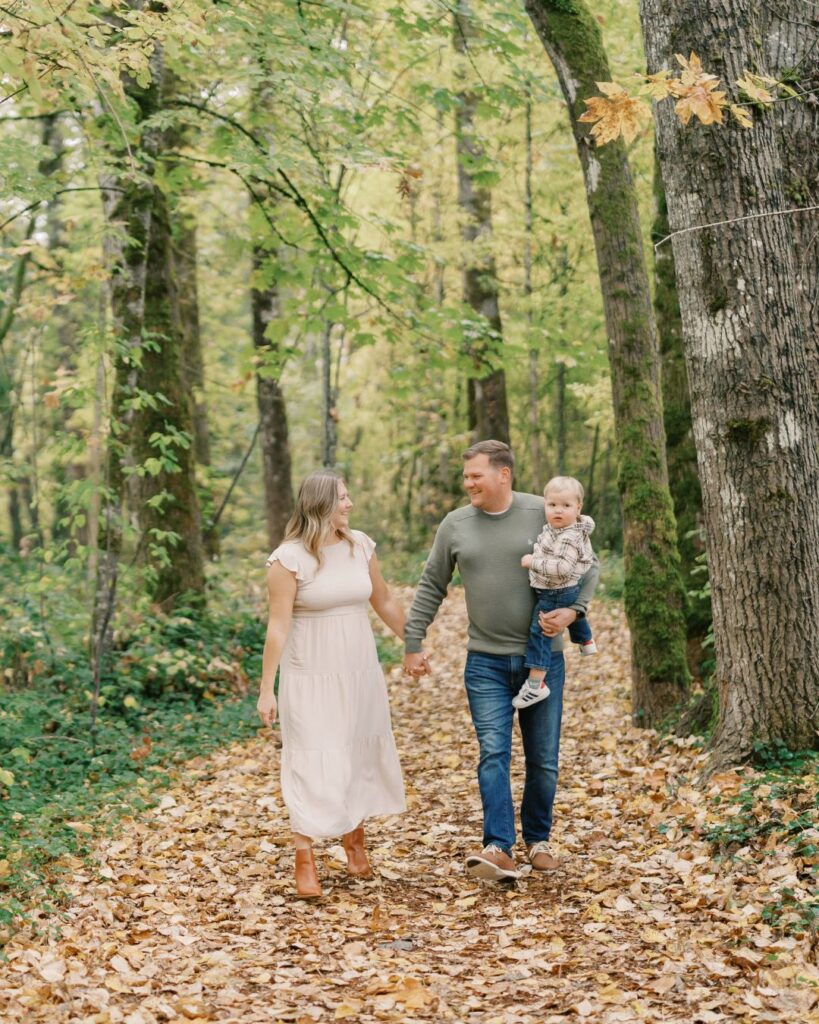 family walking through a fall forest during fall forest mini sessions near portland oregon