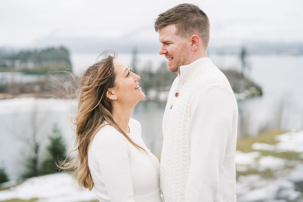 close up of couple during snowy winter maternity photos in portland oregon. columbia river is in the background.